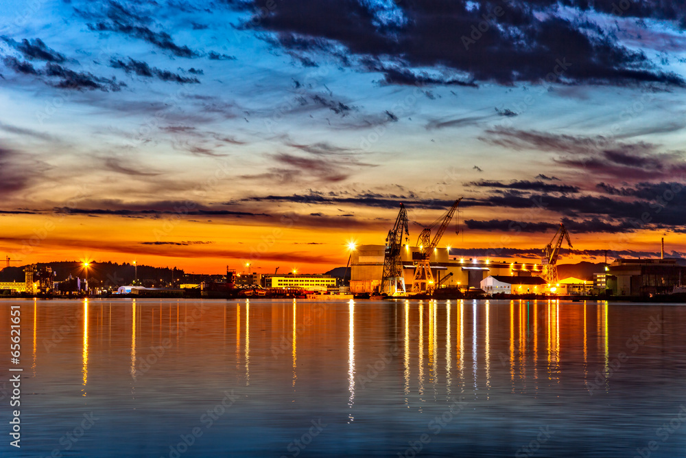 Sunset over an industry harbor with cranes in Stavanger, Norway.