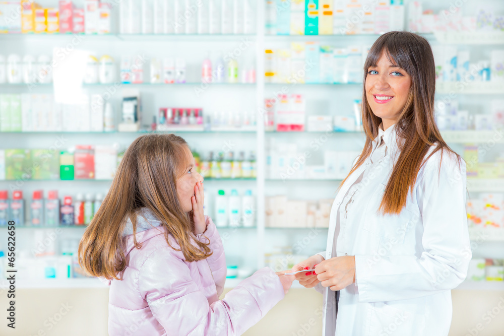  pharmacist giving vitamins to child girl in pharmacy drugstore