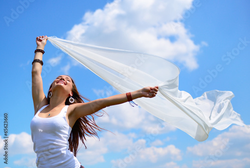 Happy young woman holding white scarf with opened arms expressin photo