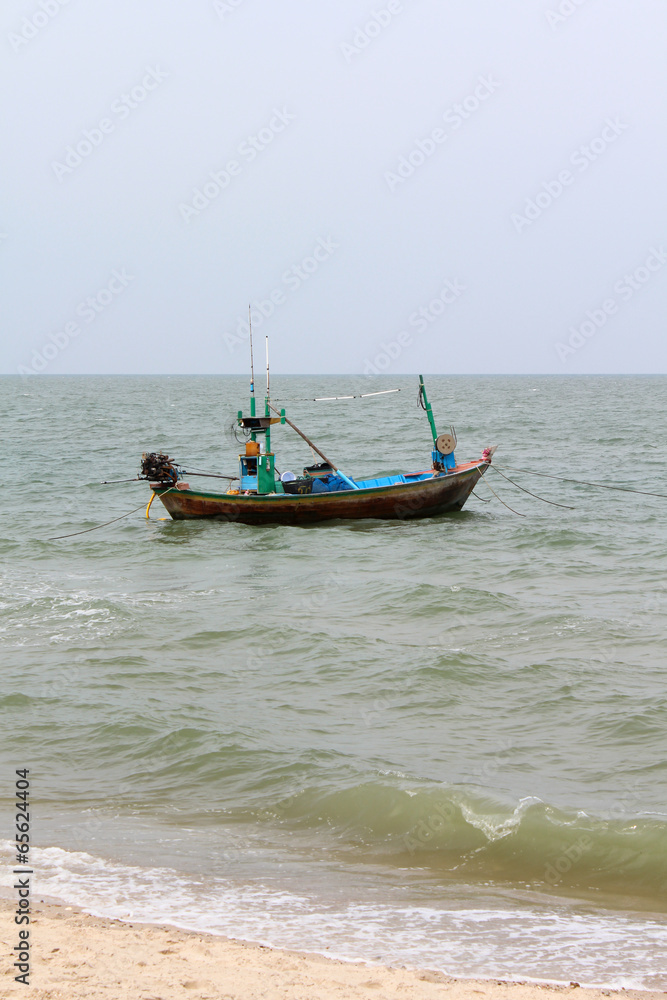 A fishing boat, sea in background and blue sky.