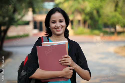Happy young female student at college campus