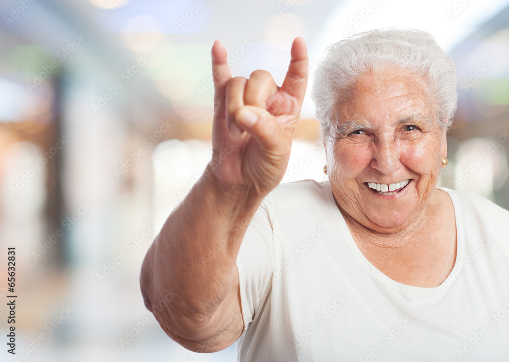 portrait of elder woman doing a rock gesture portrait of elder woman doing a rock gesture