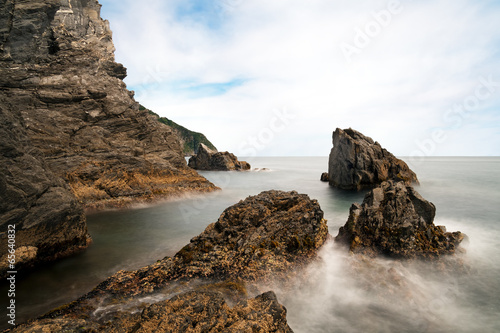 Rocky shore, coast with rocks and silky smooth sea water effect.