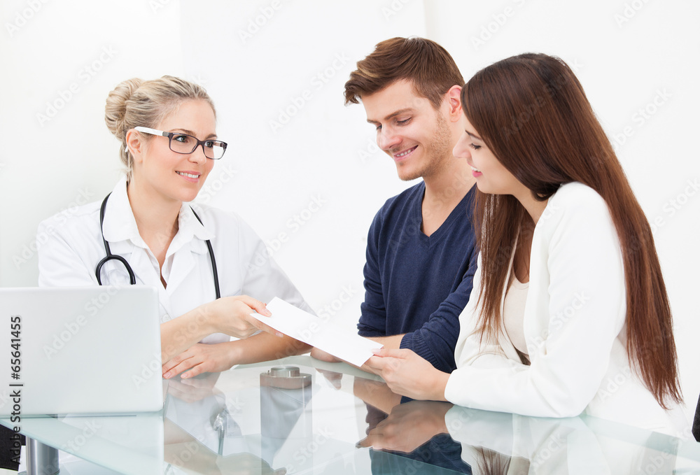 Doctor Giving Prescription Paper To Couple Doctor Giving Prescription Paper To Couple