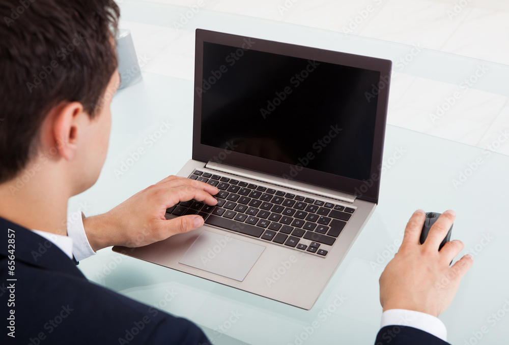 Young Businessman Using Laptop In Office