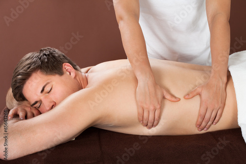 Man Receiving Back Massaging In Spa
