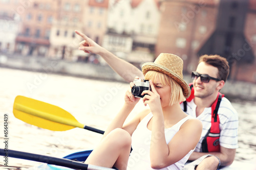 Young tourists taking pictures in a canoe