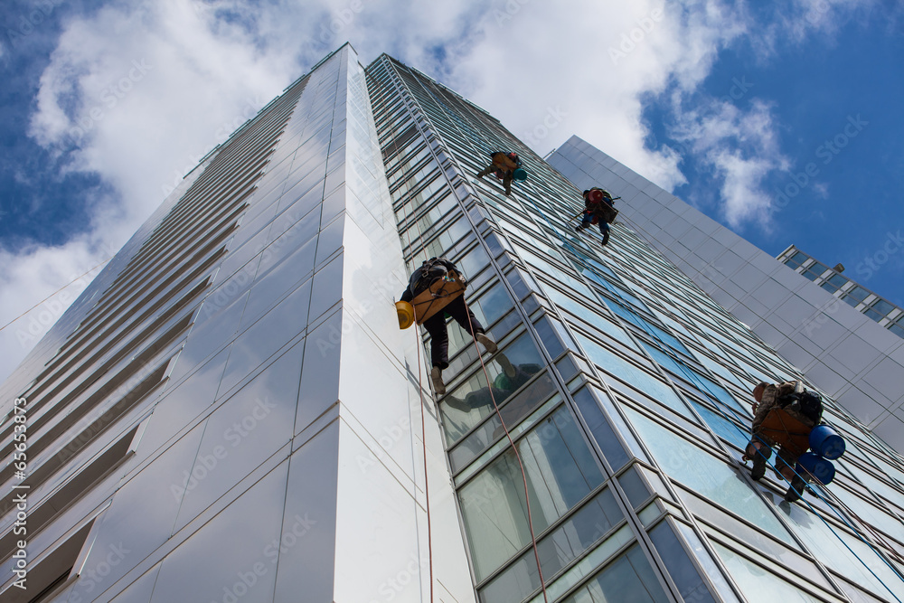 cleaning skyscrapers outside with a crane - window washing - obrazy, fototapety, plakaty 