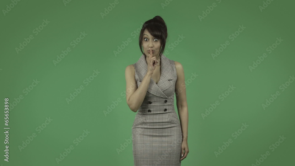indian business woman isolated on green with fingers on lips indian business woman isolated on green with fingers on lips