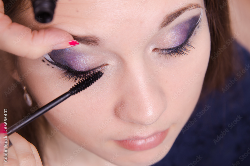 Applying mascara on the lashes model