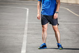 Male runner standing on racing track after workout.