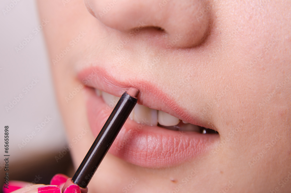 Makeup artist brings lip pencil beautiful girl