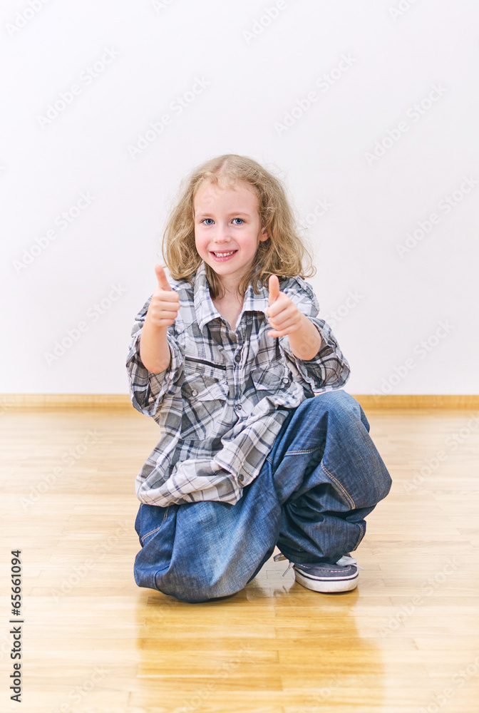Smiling little girl in oversized jeans and shirt. Smiling little girl in oversized jeans and shirt.