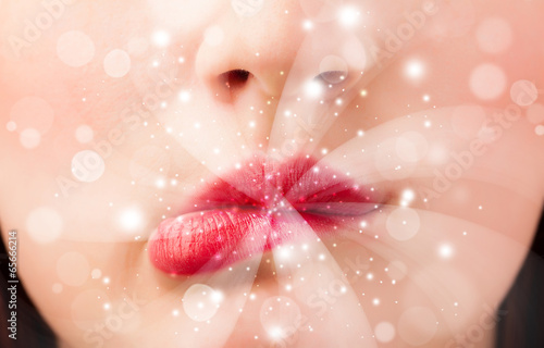 Pretty woman lips blowing abstract white lights