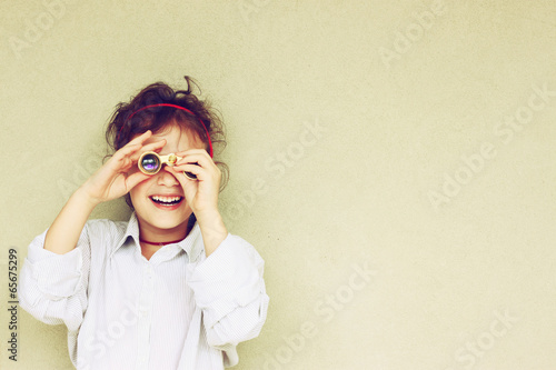 Happy kid playing with binoculars. explore and adventure concept photo