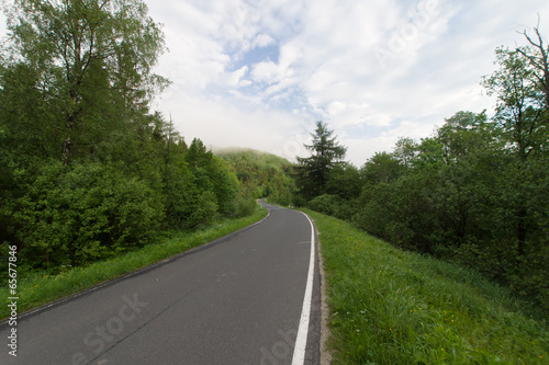 Droga asfaltowa w górach, mglisty poranek, Bieszczady © Piotr Szpakowski