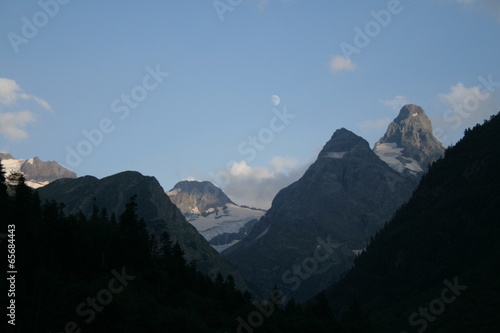 Mountain valley in the evening with the moon