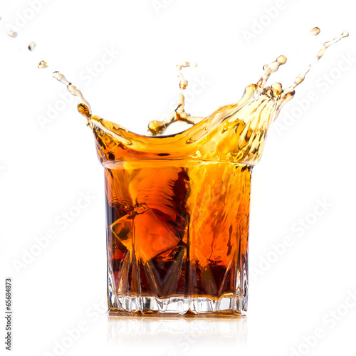 Glass with whiskey splash on white background