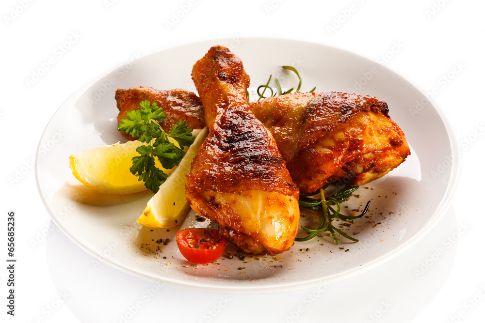 Grilled chicken legs and vegetables on white background Grilled chicken legs and vegetables on white background