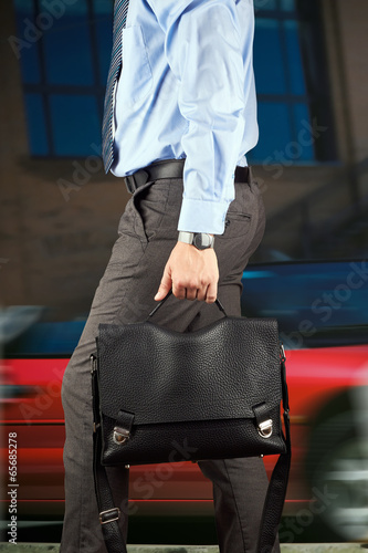 Fotografija Businessman walking and holding  a  leather briefcase in his han