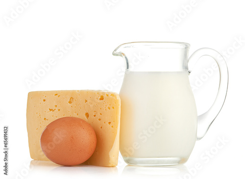 Big piece of cheese, glass jug with milk