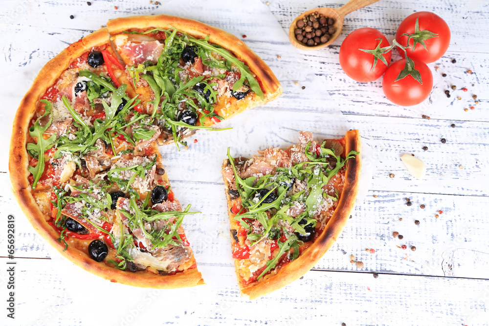 Pizza with arugula on color wooden background Pizza with arugula on color wooden background