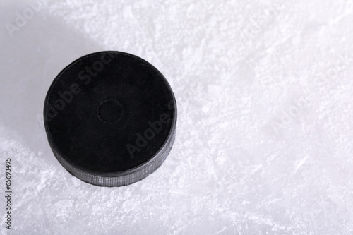 Photography Black hockey puck on ice rink background
