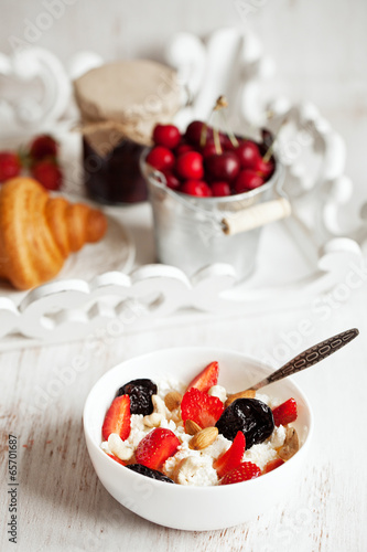 Healthy breakfast with cottage cheese, cacao, cherry and croissa