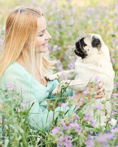 Cute blond girl having fun with her dog at the park