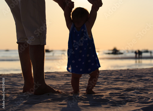 Silhouette of father and daughter on the beach