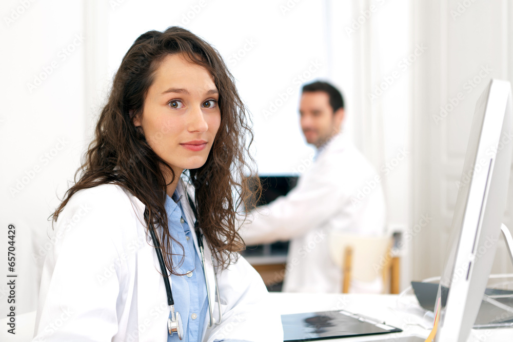 Fototapeta premium Doctor working at the office assisted with assistant