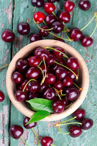 cherries in a bowl on wooden surface