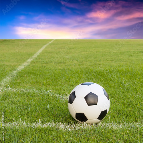 soccer ball on soccer field against sunset sky
