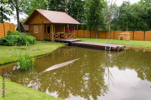 new rural bathhouse and pond with plank footbridge