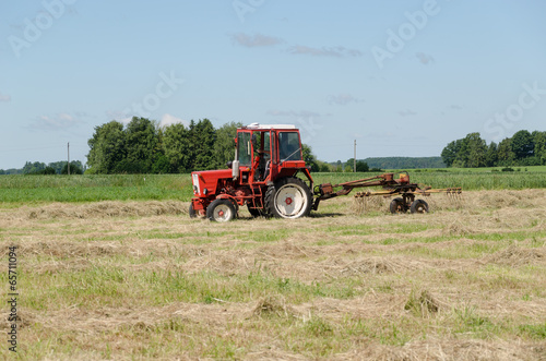 tractor ted hay dry grass in agriculture field