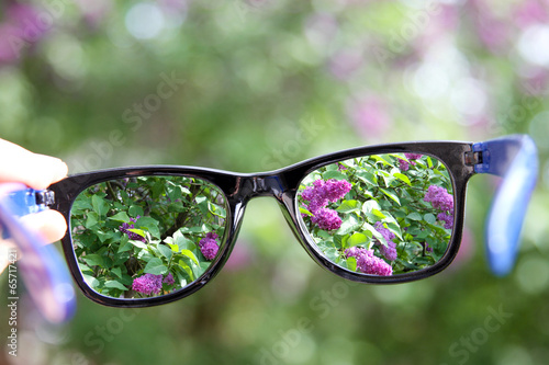 eyeglasses in the hand over blurred background