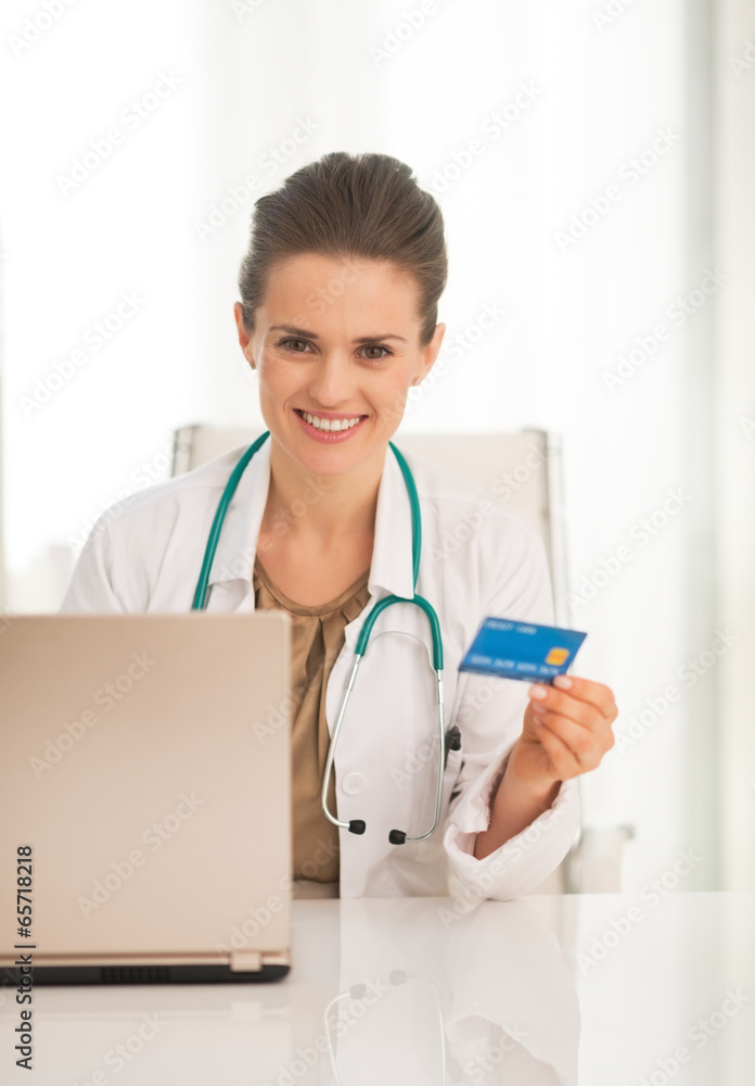 Portrait of happy medical doctor woman with credit card Portrait of happy medical doctor woman with credit card