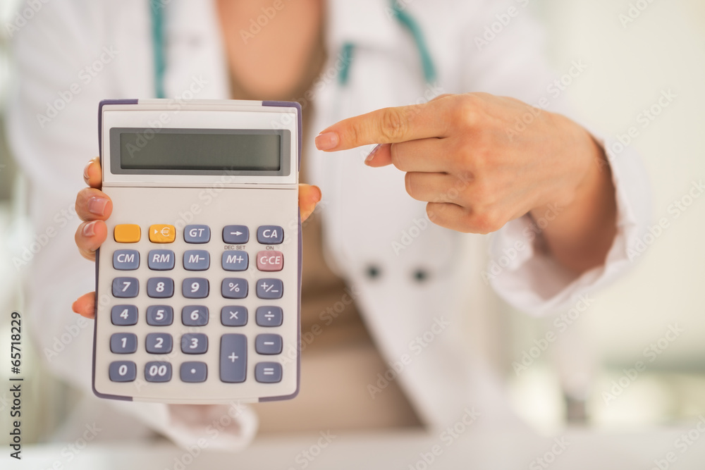 Closeup on medical doctor woman pointing on calculator Closeup on medical doctor woman pointing on calculator