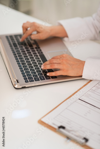 Closeup on medical doctor woman working on laptop