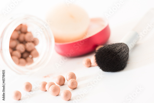 Composition of bronzing pearls and makeup brush angled