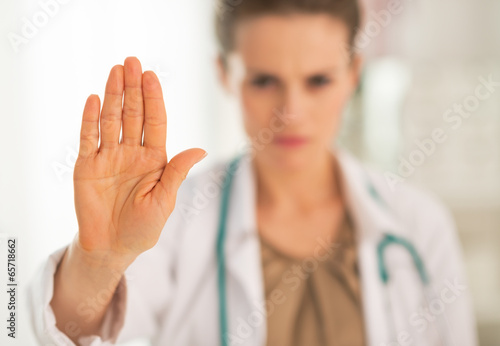 Closeup on serious medical doctor woman showing stop gesture
