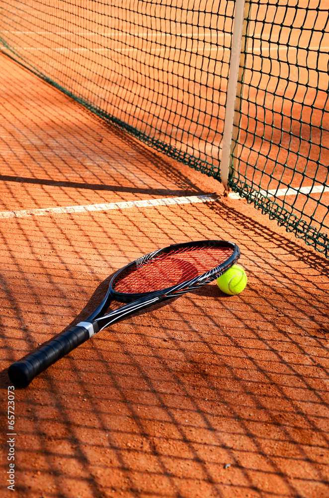 tennis ball and racket are near the net vertical