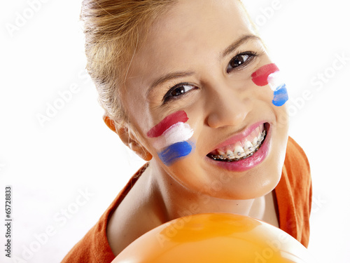 smiling girl with dutch flag painted on her face