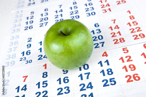 green apple on sheets of wall calendar