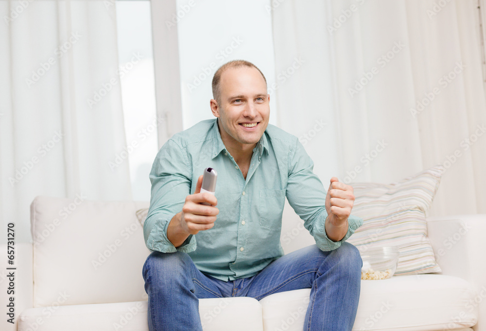 smiling man watching sports at home smiling man watching sports at home