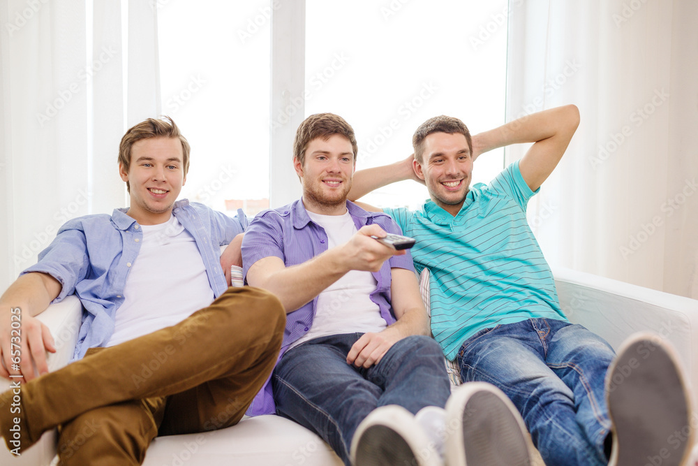 smiling friends with remote control at home smiling friends with remote control at home