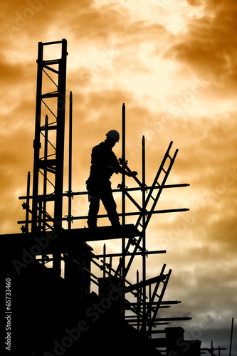 builder on scaffold building site photo