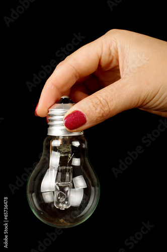 Female hand with light bulb isolated on the black background