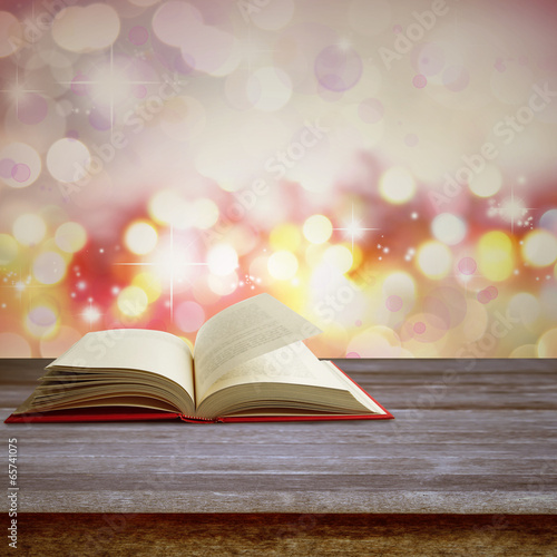 Open book on table in front of abstract background