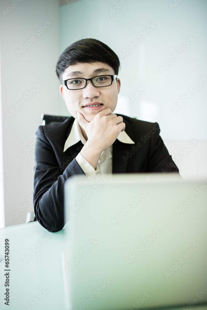 Young handsome man using laptop in his office Young handsome man using laptop in his office
